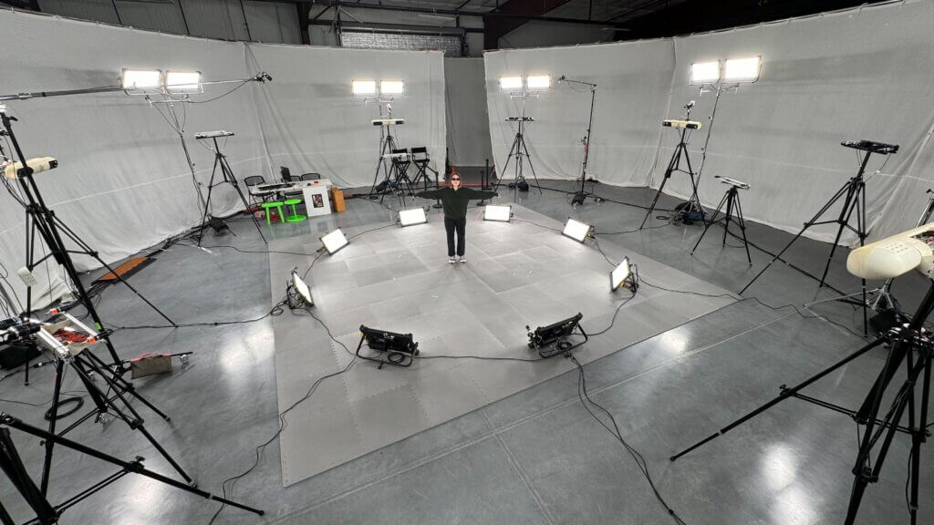 Motion capture stage with performer in tracking suit in a volumetric capture studio